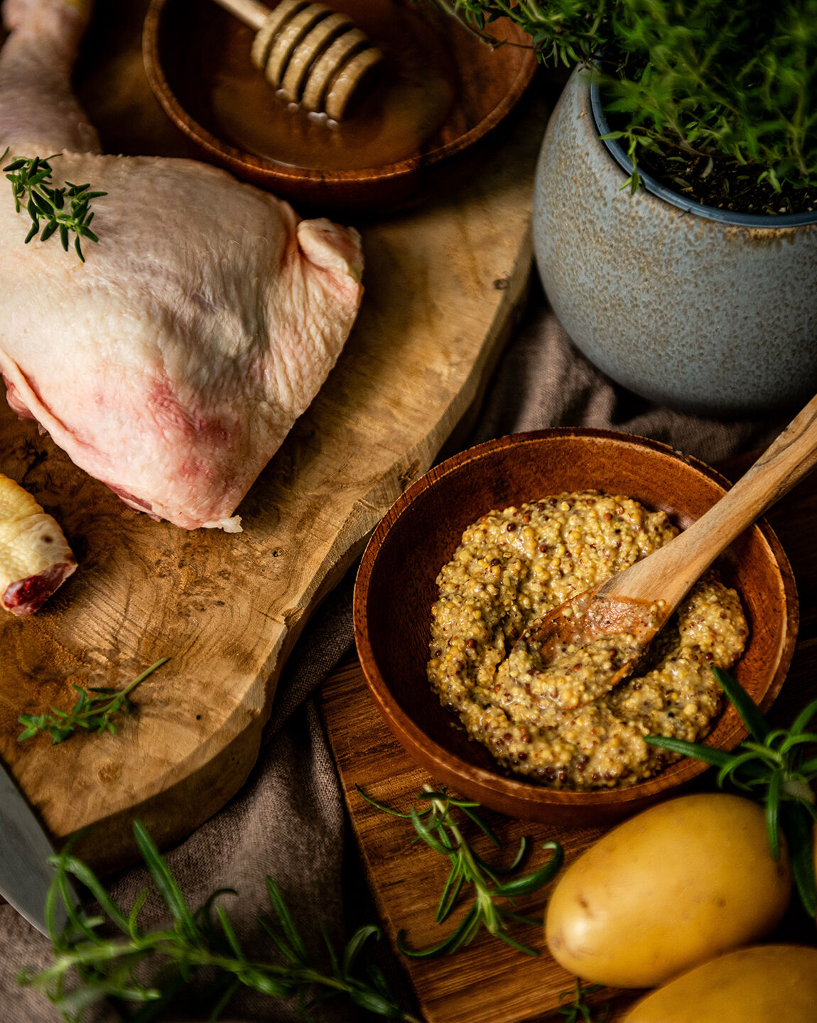 Ingrédients pour une recette de poulet miel-moutarde et mille-feuilles de pommes de terre : cuisse de poulet, miel, moutarde à l’ancienne, pommes de terre et herbes aromatiques